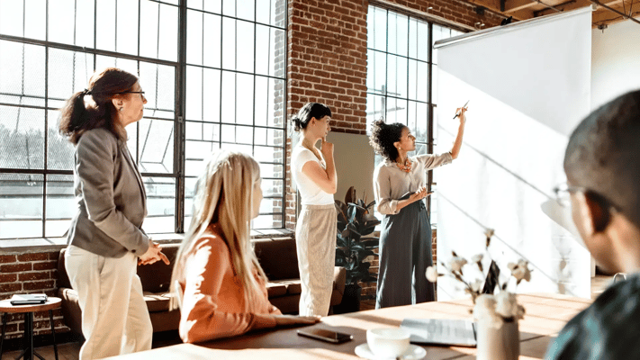 Coworkers watching a board and discussing ideas