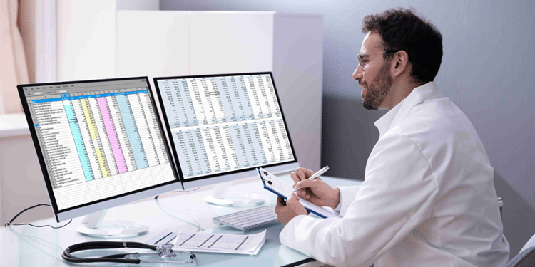 executive practicing e-invoicing implementation with two monitors