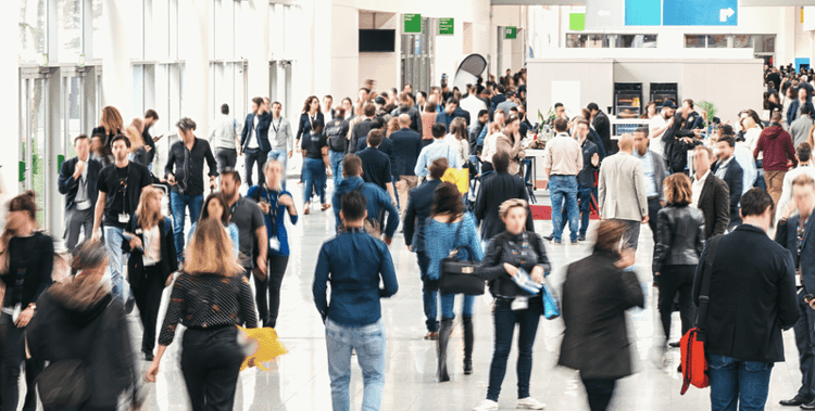 Group of people walking down a wide building corridor in different directions as a demonstration of the speed of change in our modern society